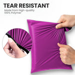 Hands stretching a pink tear-resistant mailing bag made from strong polymer to show its durable design.